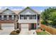 Charming two-story townhome features a well-kept front yard and a one-car garage at 173 Oakland Hills Way, Lawrenceville, GA 30044