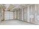 Unfinished two car garage with unfinished drywall and concrete flooring at 173 Oakland Hills Way, Lawrenceville, GA 30044
