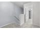 Upstairs hallway with neutral carpet and views of a second room through a doorway at 173 Oakland Hills Way, Lawrenceville, GA 30044