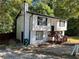 White two-story house featuring black trim, chimney, a wood porch, and a small yard at 2290 Wilkins Cv, Decatur, GA 30035