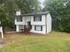 Charming two-story home featuring white siding, black trim, and a cozy, elevated front porch at 2290 Wilkins Cv, Decatur, GA 30035