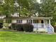 Charming single-story home featuring a cozy front porch and mature trees in a serene, landscaped yard at 1003 Valley Se Dr, Smyrna, GA 30080