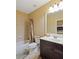 Tiled bathroom features a shower and tub combination, vanity, toilet, and decorative rug at 1255 Mcminn Way, Snellville, GA 30078