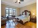 Bedroom with hardwood floors, a window seat and carved furniture including a tufted headboard and side tables at 1255 Mcminn Way, Snellville, GA 30078