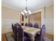 Elegant dining room with hardwood floors, wainscoting and a chandelier above a formal table with seating for eight at 1255 Mcminn Way, Snellville, GA 30078