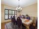 Formal dining room with decorative chandelier, wainscoting, shutters, and a long dining table at 1255 Mcminn Way, Snellville, GA 30078