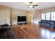 Spacious living room with hardwood floors, ceiling fan, and comfortable black leather couches at 1255 Mcminn Way, Snellville, GA 30078
