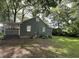 Spacious backyard with mature trees, a green lawn, and a covered deck for outdoor enjoyment at 2591 Perkerson Dr, Austell, GA 30168