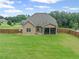 Spacious backyard offers a large manicured lawn, a screened porch, and a wooden fence for privacy at 108 Donovan Ave, Locust Grove, GA 30248