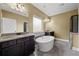 Modern bathroom featuring a soaking tub, double vanities with granite countertops, and tiled floors at 108 Donovan Ave, Locust Grove, GA 30248