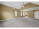 Large main bedroom featuring vaulted ceilings, carpet, and a glimpse into the attached bathroom with tub at 108 Donovan Ave, Locust Grove, GA 30248