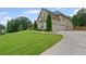 Side view of a tan two-story home showing a well-manicured lawn and a wide driveway at 108 Donovan Ave, Locust Grove, GA 30248