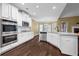 Modern kitchen boasts white cabinets, stainless steel appliances, granite countertops, and hardwood floors at 108 Donovan Ave, Locust Grove, GA 30248