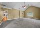 Carpeted Living room with ceiling fan, large window, and view of the modern kitchen with stainless steel appliances at 108 Donovan Ave, Locust Grove, GA 30248