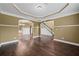 Open-concept living room featuring hardwood floors, elegant trim, and an archway leading to the foyer at 108 Donovan Ave, Locust Grove, GA 30248
