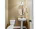 Simple powder room features a pedestal sink, an oval mirror, and a toilet at 108 Donovan Ave, Locust Grove, GA 30248
