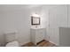 Bright bathroom featuring a white vanity with a wooden-framed mirror and a white door at 172 White Rose Ln, Temple, GA 30179