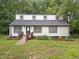 Home featuring a wooden ramp, black framed windows, and fresh landscaping, surrounded by a lush lawn and greenery at 172 White Rose Ln, Temple, GA 30179