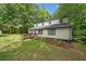 View of the home showing the wooden ramp, black framed windows, and fresh landscaping, with a carport at 172 White Rose Ln, Temple, GA 30179