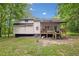 Back of house featuring an elevated wooden deck and stairs in a spacious backyard setting at 172 White Rose Ln, Temple, GA 30179