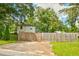 Charming backyard features a long wooden fence, green grass, and plenty of trees at 2200 Glendale Dr, Atlanta, GA 30032