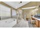 Bright bathroom featuring a soaking tub, glass-enclosed shower, and vanity area at 4055 Inman Park Ln, Buford, GA 30519