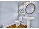 Bathroom features a pedestal sink and decorative mirror at 4055 Inman Park Ln, Buford, GA 30519