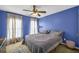 Bedroom with blue walls, neutral curtains, and a cozy gray bed at 4055 Inman Park Ln, Buford, GA 30519