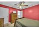 Bedroom featuring red walls, wood dresser, and ceiling fan at 4055 Inman Park Ln, Buford, GA 30519