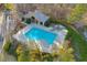 Aerial view of the community pool with a sundeck, mature landscaping, and fencing at 4055 Inman Park Ln, Buford, GA 30519