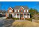 Beautiful two-story brick home featuring a classic design and covered front porch at 4055 Inman Park Ln, Buford, GA 30519