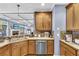 Beautiful kitchen with wooden cabinets, stainless steel dishwasher, and an open view to the living room at 4055 Inman Park Ln, Buford, GA 30519