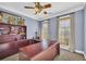 Bright office with a wooden desk, shelving unit, ceiling fan, and windows offering lots of natural light at 4055 Inman Park Ln, Buford, GA 30519