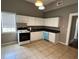 Functional kitchen with white cabinets, a black countertop, an oven and light-colored tile flooring at 3155 E East Point E St, East Point, GA 30344