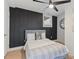 Bedroom boasts contemporary fan, accent wall, bed with pillows, and hardwood flooring at 1505 Ezra Church Nw Dr, Atlanta, GA 30314