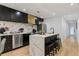 Modern kitchen featuring black cabinets, stainless steel appliances, and a stylish waterfall island with bar stool seating at 1505 Ezra Church Nw Dr, Atlanta, GA 30314