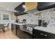Kitchen showcasing stainless steel appliances, marble countertops, and hexagon tile backsplash at 1505 Ezra Church Nw Dr, Atlanta, GA 30314