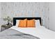 Close up of a Queen bed in a modern bedroom with patterned wallpaper and orange throw pillows at 1566 Ezra Church Nw Dr, Atlanta, GA 30314