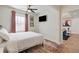 Bright bedroom featuring a ceiling fan, TV, neutral walls, and a door leading to a living space at 749 Bonnie Brae Sw Ave, Atlanta, GA 30310