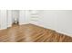 Basement area with modern laminate flooring and built-in shelving, leading to a partial bathroom at 502 Bridge Se Ln, Smyrna, GA 30082