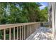View of a wooden deck and railing that is adjacent to a tree-filled area at 502 Bridge Se Ln, Smyrna, GA 30082