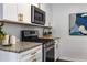 Updated kitchen shows stainless steel oven, white cabinets with gold hardware and a modern aesthetic at 502 Bridge Se Ln, Smyrna, GA 30082