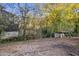 View of the side and back of a home, revealing the yard with trees and storage sheds in a quiet neighborhood at 5861 Community Rd, Mableton, GA 30126