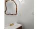 Close-up of bathroom with antique-style framed mirror, single vanity, and modern light fixture at 5861 Community Rd, Mableton, GA 30126
