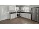 Well-lit kitchen featuring stainless steel appliances, white cabinets and dark countertops at 5861 Community Rd, Mableton, GA 30126
