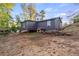 View of the back of a house with a small animal house, showing the landscape in a somewhat rural setting at 5861 Community Rd, Mableton, GA 30126