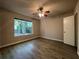 This bedroom includes neutral walls, ceiling fan, and wood-look flooring, all illuminated by a large window at 33 Drew Ct, Jonesboro, GA 30238