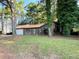 A single story home with brown siding, a stone chimney and a one car garage at 33 Drew Ct, Jonesboro, GA 30238