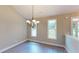 Bright dining area featuring laminate floors, a modern chandelier, and large windows at 504 Iris Way, Villa Rica, GA 30180