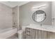 Modern bathroom featuring a sleek vanity, circular mirror, and tiled shower and tub at 1099 North Ne Ave # 11, Atlanta, GA 30307
